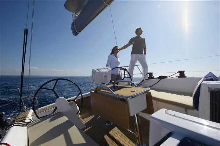 man and a woman enjoying in a yacht. They are looking the beauty of the sea.